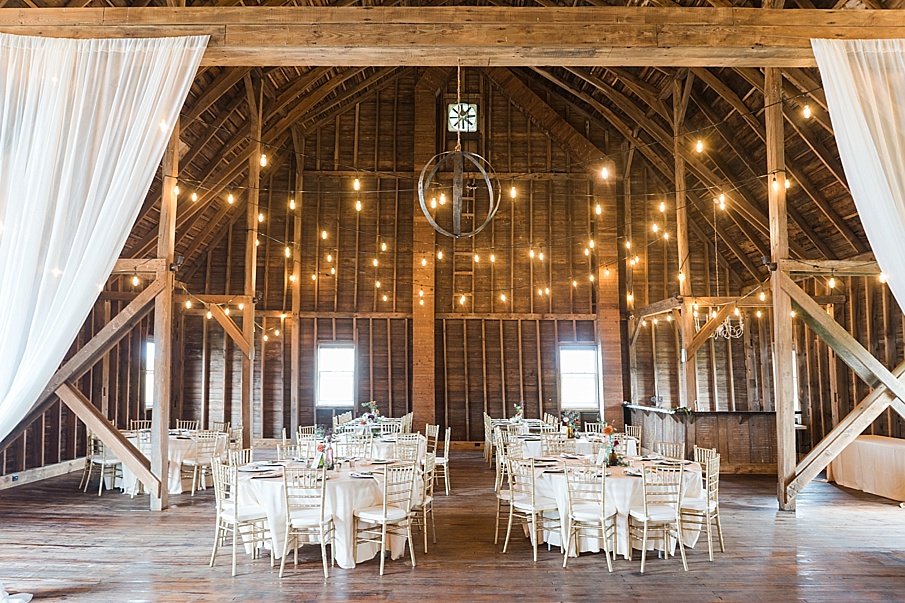 indoor reception with white tables and string lights at the Farm at Cottrell Lake