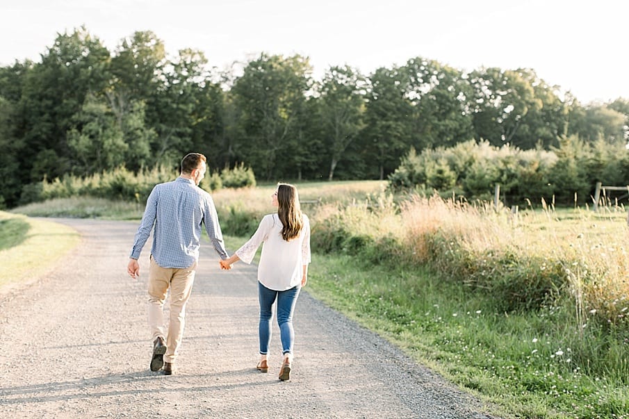 engaged couple walking down dirt road holding hands in Pennsylvania